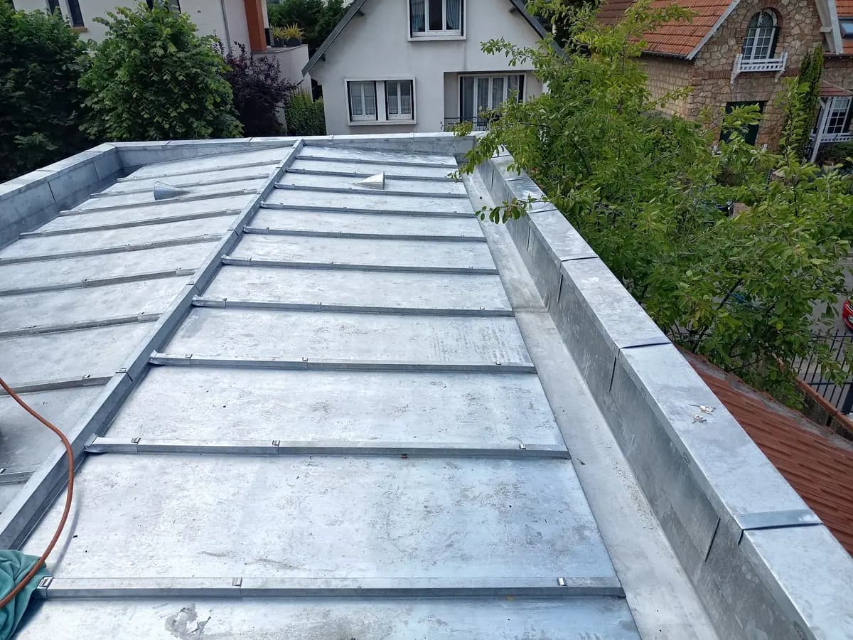 Vue d’ensemble d’une couverture neuve en zinc à tasseaux sur une toiture de faible pente