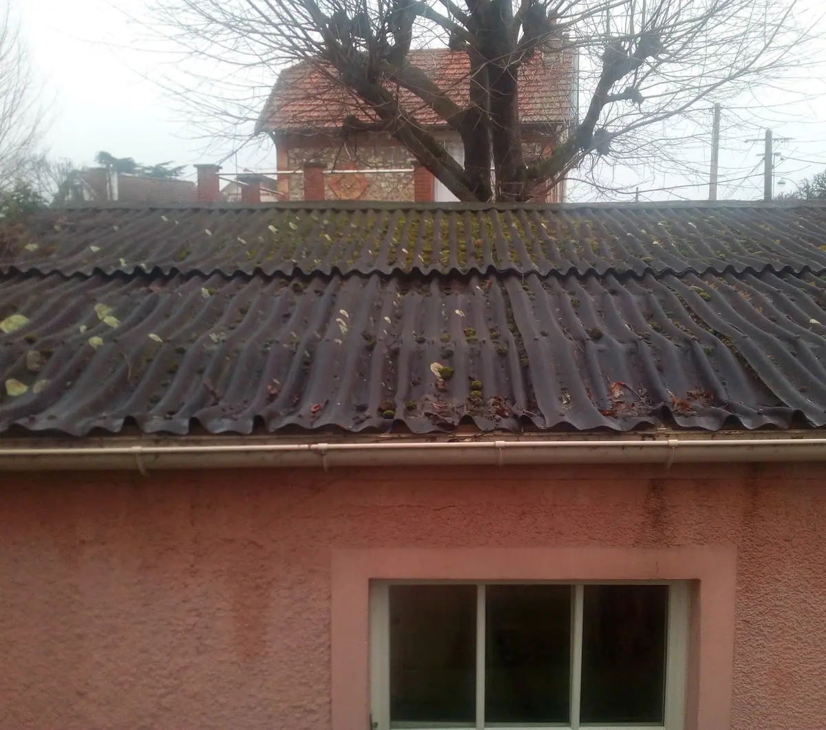 Ancienne couverture en plaques ondulées envahie de mousses et de feuilles, avant réfection