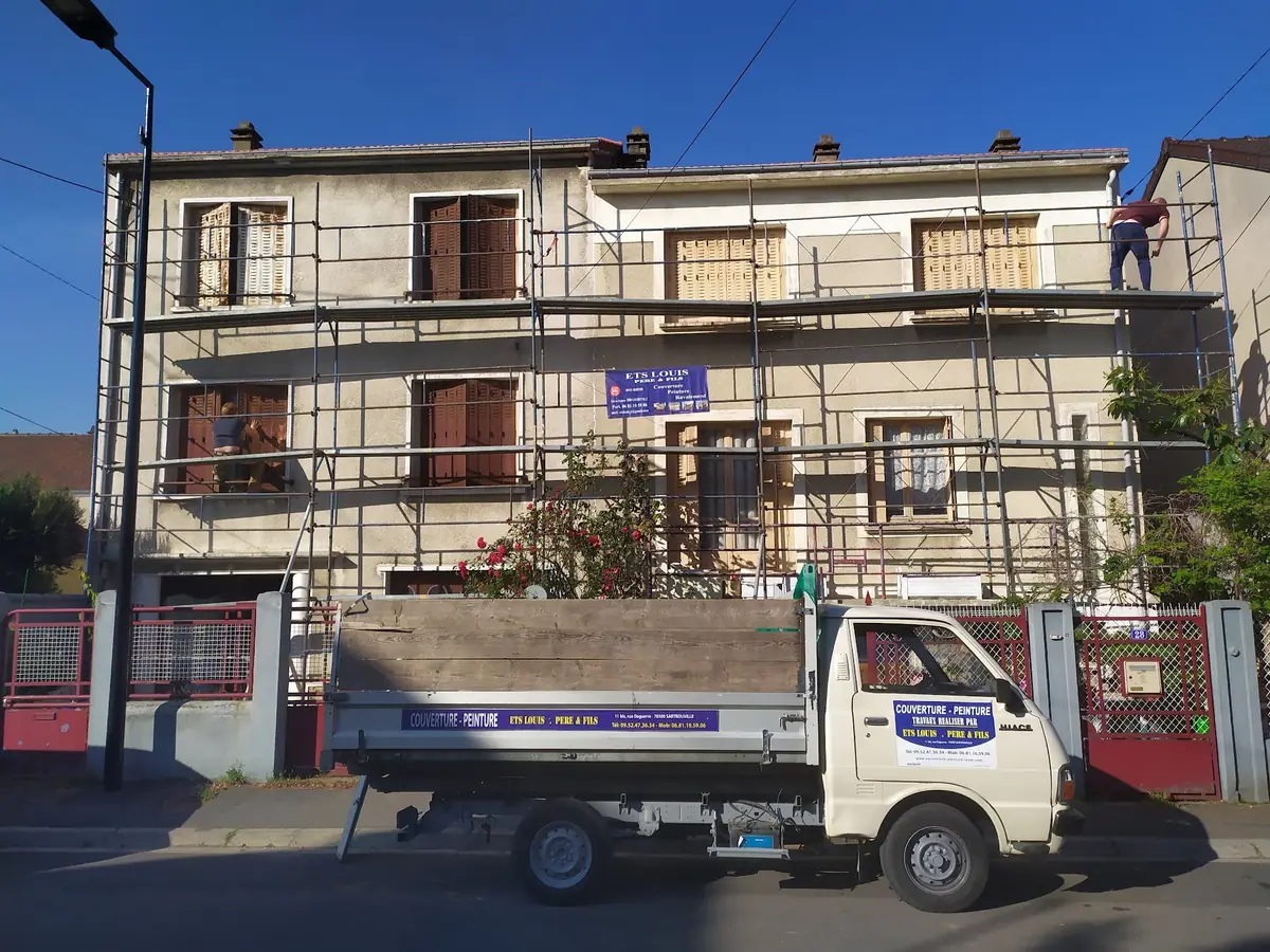 Chantier de ravalement en cours : echafaudage sur toute la facade, camion et panneau de chantier ETS Louis Père et Fils